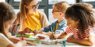 Maestro ayudando a los niños con las tareas escolares